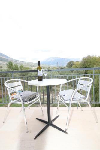 a table with two chairs and a bottle of wine at Cosmos Apartments in Vasiliki