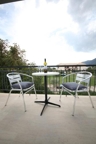 two chairs and a table with a bottle of wine at Cosmos Apartments in Vasiliki