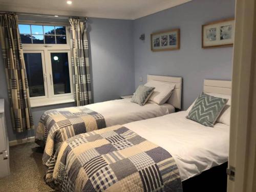 two beds in a room with a window at Atlantic Lodge in Newquay