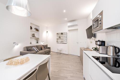 a white kitchen and living room with a couch at Cinque Terre Bridge in La Spezia
