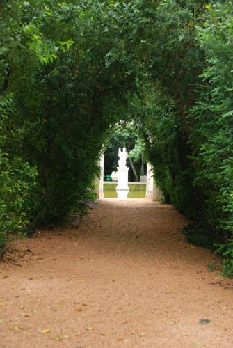 an archway in a park with a fountain in the distance at Hotel Rural Quinta de Santo Antonio in Elvas