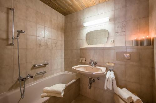 a bathroom with a sink and a bath tub and a sink at Gästehaus Rauch in Schwendau