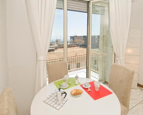 ナポリにあるSan Giacomo 32 Residenceのダイニングルーム(白いテーブル、大きな窓付)