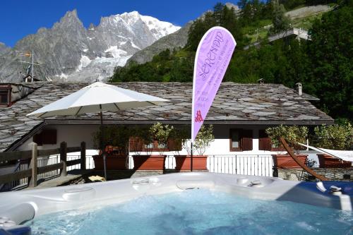 a hot tub with a sign in front of a house at Hotel Pilier D'Angle & Wellness in Courmayeur