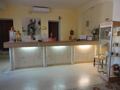 a woman standing at a counter in a room at Hotel Rural Quinta de Santo Antonio in Elvas
