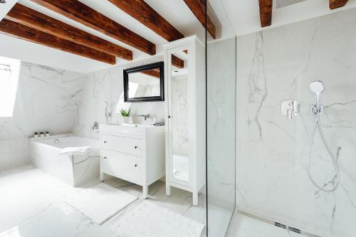 a white bathroom with a shower and a toilet at Loft v historickom centre in Trenčín