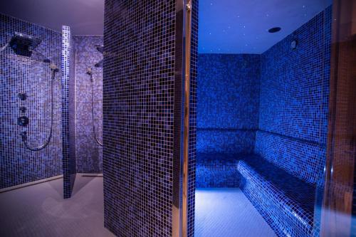 巴爾德羅夫雷斯的住宿－Hotel Mas de la Costa ****，蓝色瓷砖浴室设有浴缸和淋浴。