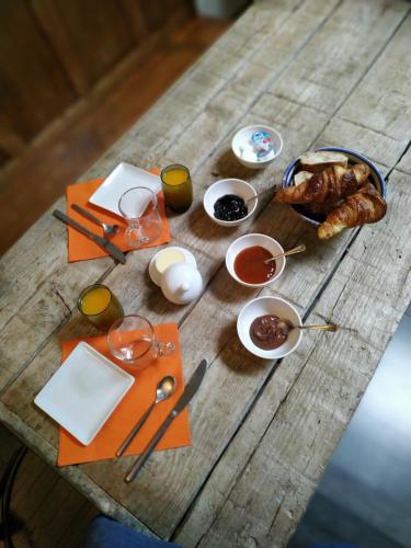 a wooden table with food and utensils on it at Chez Anne in Fécamp