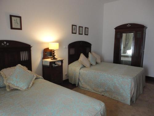 a hotel room with two beds and a lamp at Hotel Rural Quinta de Santo Antonio in Elvas