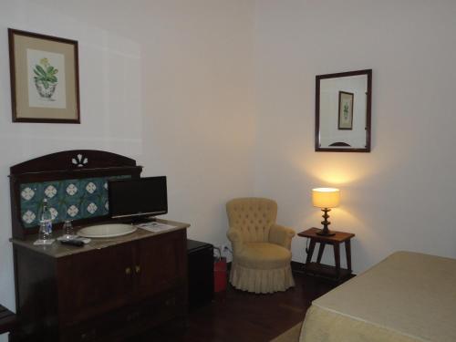 a room with a bed and a desk and a chair at Hotel Rural Quinta de Santo Antonio in Elvas