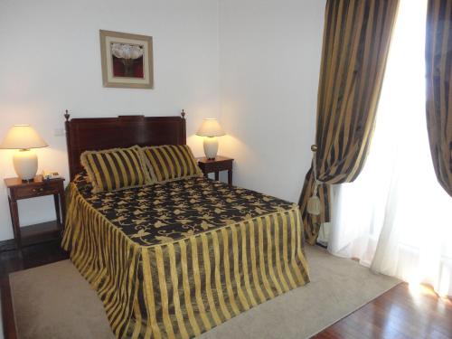a bedroom with a bed and two lamps on tables at Hotel Rural Quinta de Santo Antonio in Elvas