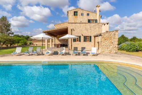 a villa with a swimming pool in front of a house at Son Mesquida d'Abaix in Algaida