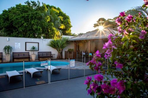 een huis met een zwembad en paarse bloemen bij Hotel Jardim in Jardim
