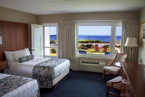 グロスターにあるAtlantis Oceanfront Inn Gloucesterのベッドが2つと窓があるホテルの部屋