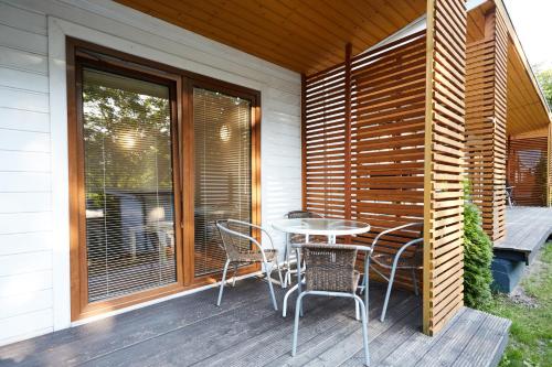 a patio with a table and chairs on a deck at Metropolis Domki in Sopot