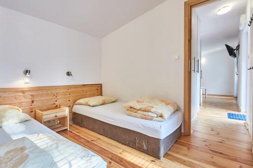 a bedroom with two beds and a mirror at Metropolis Domki in Sopot