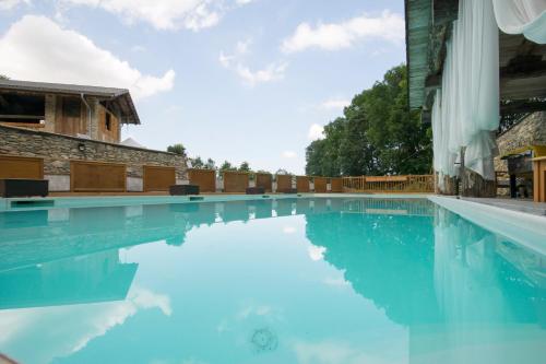 uma piscina com água azul em Il Sogno Della Vita AgriResort - Country Rooms & Suites em Peveragno