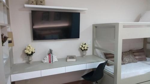 a white bunk bed with a desk and a television at Loft Res Pedra Azul - hospedagem nas montanhas in Pedra Azul