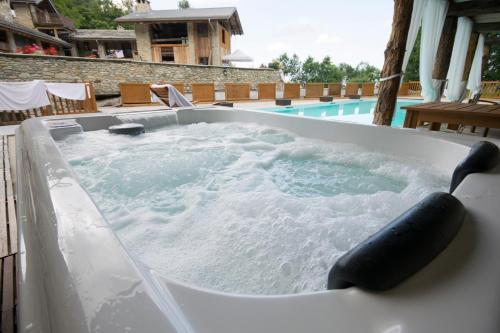 uma banheira de hidromassagem ao lado de uma piscina em Il Sogno Della Vita AgriResort - Country Rooms & Suites em Peveragno