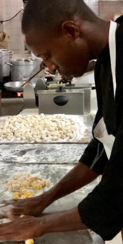 a man is making food in a kitchen at Aquarius Club in Watamu