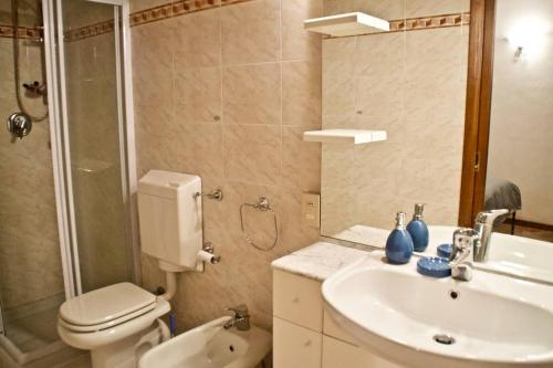 a bathroom with a toilet and a sink and a shower at Casa Francesca in Gargnano