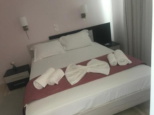 a bed with two pairs of white towels on it at Terpsichore Boutique Appartments in Dassia