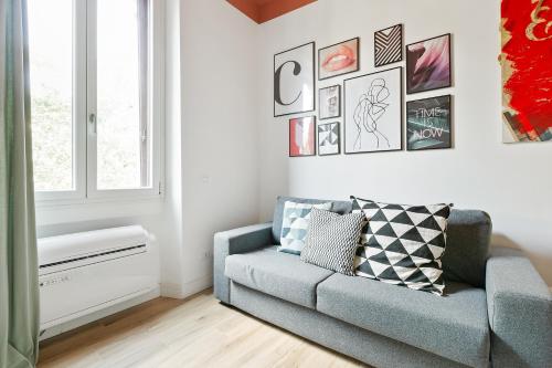 - un salon avec un canapé et des photos sur le mur dans l'établissement Modern and cozy apt in Porta Romana, à Milan