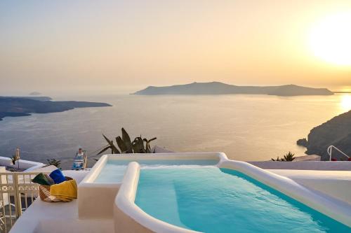a swimming pool with a view of the ocean at Mirabo Villas in Firostefani