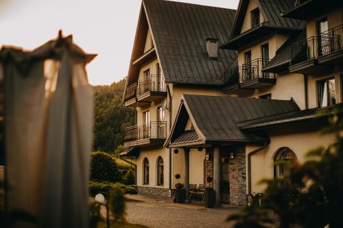 a large building with a black roof at Pensjonat Jurkowski Wellness & Spa in Ochotnica Dolna