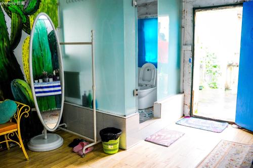 a bathroom with a mirror and a surfboard in it at Yellow House Hostel Huizhou West Lake in Huizhou