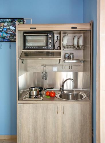 a small kitchen with a sink and a microwave at Lazy Lizard in Néa Karváli