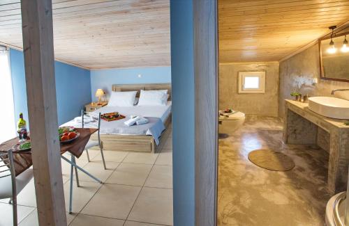 ein Schlafzimmer mit einem Bett und ein Badezimmer mit einem Waschbecken in der Unterkunft Lazy Lizard in Néa Karváli