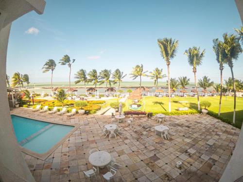 ein Luftblick auf ein Resort mit einem Pool und Palmen in der Unterkunft Flat Apart Hotel Marinas Tamandaré in Tamandaré