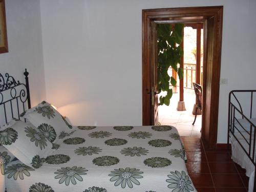 a bedroom with a bed with a flowered comforter at Casa Rural La Era Vieja en Vallehermoso La Gomera in Vallehermoso