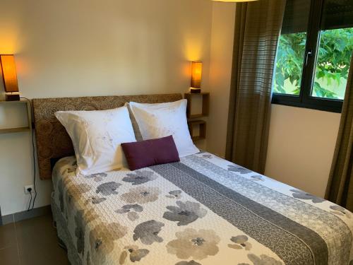 a bedroom with a bed with a pillow on it at Le Clos du Pontet in Orliénas