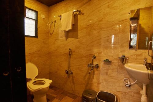 a bathroom with a toilet and a sink at Hotel Disha Palace in Shirdi