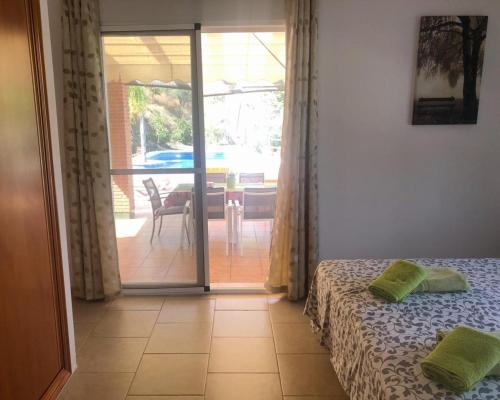 een slaapkamer met een bed en een glazen schuifdeur bij Peperent Villa Al-Andalus in Cómpeta