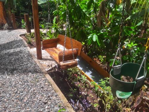 a wooden swing in a garden with a bucket at Utopia Eco Hotel in Lanquín