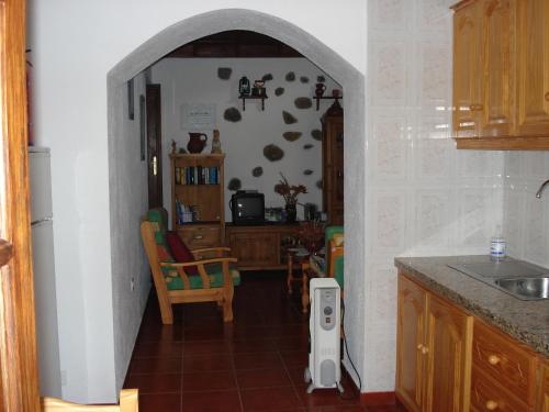 Casa Rural La Era Vieja en Vallehermoso La Gomera في فاليهيرموسو: مطبخ مع ممر يؤدي إلى غرفة طعام