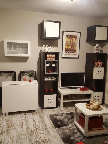 un salon avec une télévision et une table dans l'établissement Apart T2 pied pistes Pyrénées 2000 récemment rénové Wifi, à Bolquère-Pyrénées 2000