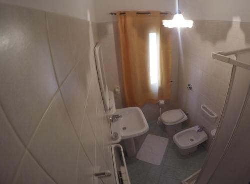 un piccolo bagno con lavandino e servizi igienici di Casa Vacanze Il Cortile a Custonaci