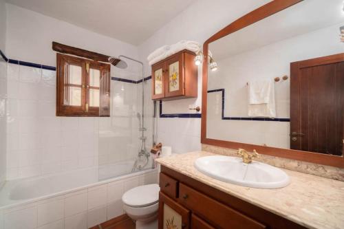 y baño con lavabo, bañera y aseo. en Villa with views and private pool near Malaga., en Colmenar