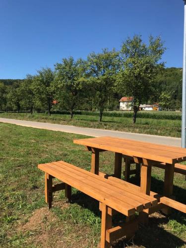 a wooden picnic table sitting in a field at Apartman Karlo in Otočac