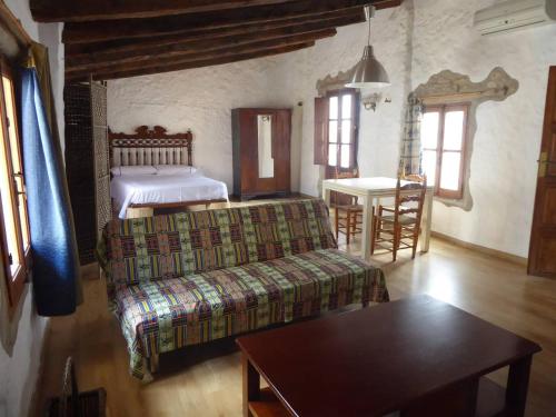 ein Schlafzimmer mit einem Bett, einem Sofa und einem Tisch in der Unterkunft Casa de Cáliz Xàtiva in Xàtiva