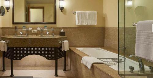 Elegant Apartment in a Luxury Resort في شرم الشيخ: حمام مع حوض وحوض ومرآة