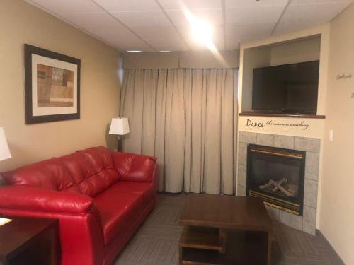 a living room with a red couch and a fireplace at Days Inn by Wyndham Hinton in Hinton