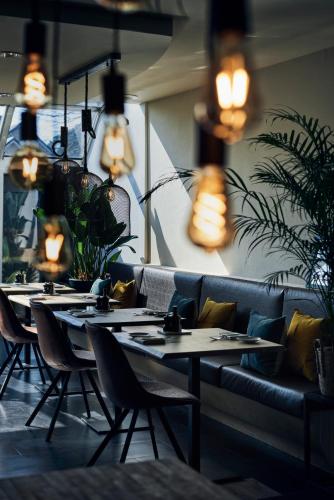 a row of tables and chairs in a restaurant with lights at Hotel Zuid in Genk