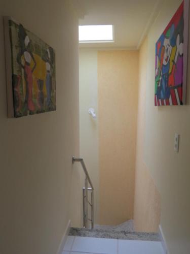 a bathroom with a shower and a painting on the wall at Guest House Paraiso Pataxos in Porto Seguro