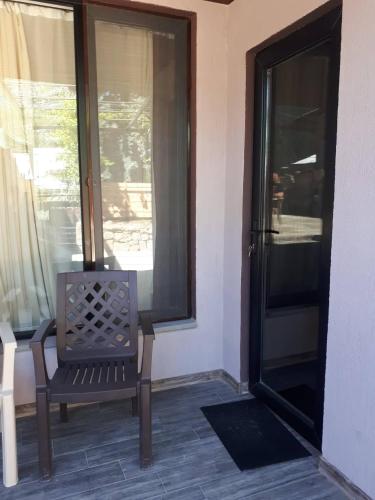 a chair sitting on a porch next to a window at Vaso&Iro Guest House in Borjomi