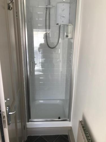 a shower with a glass door in a bathroom at The Old Butchers in Northampton